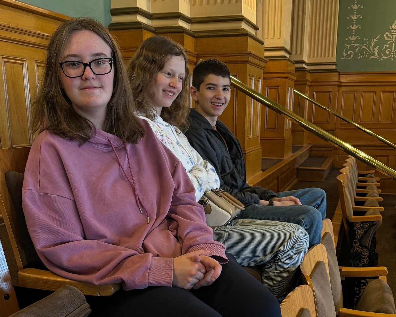 Students seated at the Capitol, smiling for the camera